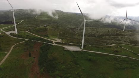 Turbinas-Eólicas-En-Las-Montañas-Durante-El-Amanecer-Y-La-Espesa-Niebla-Matutina-En-El-Valle