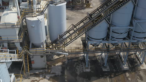 Drone-shot-of-a-truck-pulling-into-an-asphalt-plant-to-be-loaded