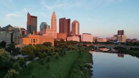 Aerial-golden-hour-ascent-to-city-skyline-from-trees---Columbus,-Ohio