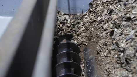 closeup-of-automated-auger-loading-processed-wood-chip-into-a-biomass-boiler