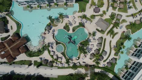 Aufsteigende-Luftaufnahme-Eines-Einzigartigen-Pools-Und-Seiner-Umgebenden-Resortmerkmale