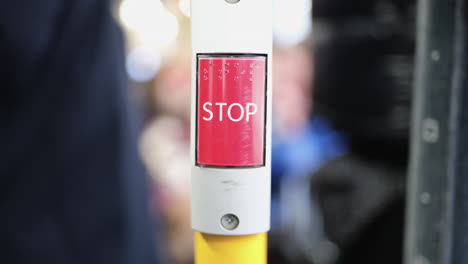 Stop-Taste-In-Einem-Bus-Mit-Passagieren-Im-Verschwommenen-Hintergrund
