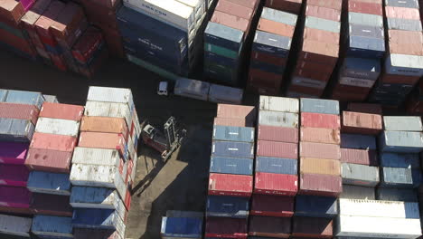 Aerial-drone-shot-of-an-empty-container-handler-forklift-in-a-shipping-container-yard
