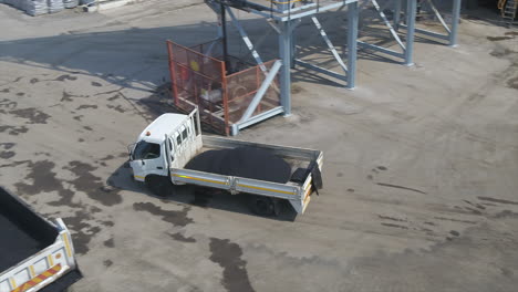 Aerial-drone-shot-of-a-truck-loaded-with-asphalt