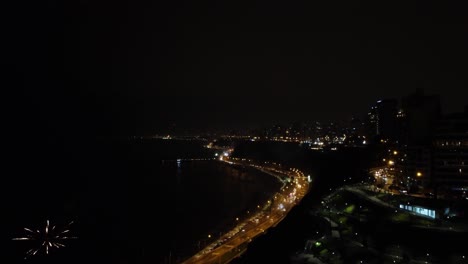 Drone-video-of-the-coast-of-Lima,-Peru-called-"Costa-Verde"-during-the-night-time-new-years-celebrations