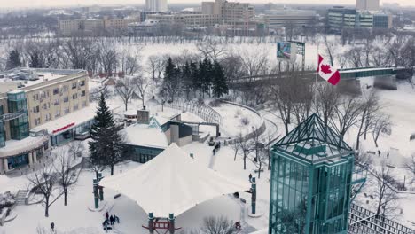 Aerial-pan-around-blowing-Canadian-flag-in-downtown-Winnipeg-in-winter