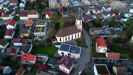 Circle-Drone-shot-of-Martinskirche-in-the-small-town-Lahr,-Schwarzwald,-Germany