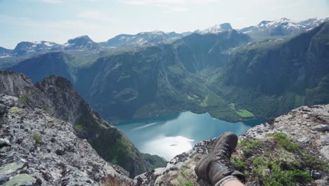 Hiker-Sitting-By-The-Edge-Of-The-Mountain-In-Katthammaren-Norway---wide-shot