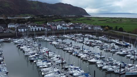 Luxurious-yachts-moored-in-wealthy-Welsh-mountain-marina-aerial-view-orbit-left