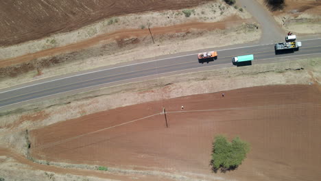 Top-down-aerial-of-truck-driving-over-road-in-rural-Kenya,-Africa