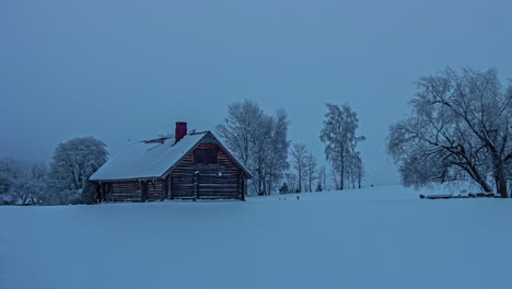Timelapse-shot-of-wooden-cottage-in-distance-covered-thick-layers-of-snow-on-a-cold-winter-day