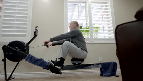 Senior-overweight-man-exercising-on-a-rowing-machine-ends-his-workout