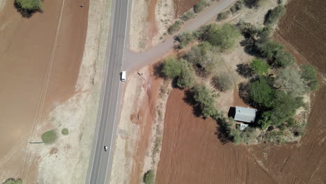 Top-down-Aerial-of-motorcycle-driving-over-a-single-road-in-rural-Kenya