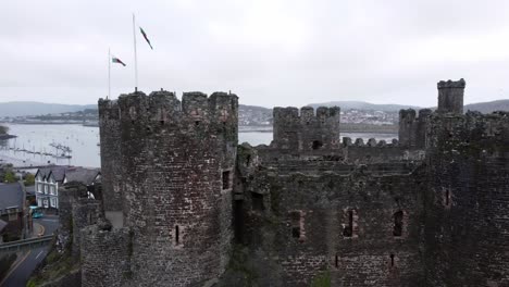 Historic-Conwy-castle-aerial-view-of-Landmark-town-ruin-stone-wall-battlements-tourist-attraction-rising-left-orbit