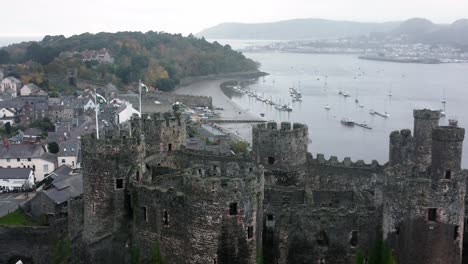 Historic-Conwy-castle-aerial-descending-view-across-Landmark-town-ruin-stone-wall-battlements-tourist-attraction