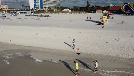 Drone-Shot-of-man-standing-on-a-beach-revealing-the-landscape
