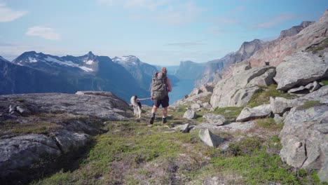 Caucasian-Hiker-Walking-In-A-Mountain-Path-In-Katthammaren-Mountain-With-A-Dog---wide-shot