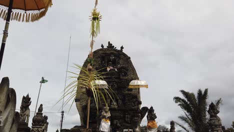 Balinese-Temple-in-the-Streets-of-Batuan,-Sukawati,-Dragon-Statues,-Guardians,-Umbrellas-and-Offerings-in-the-Architectural-Entrance-of-the-Hindu-Bali-Religion-Sacred-Space