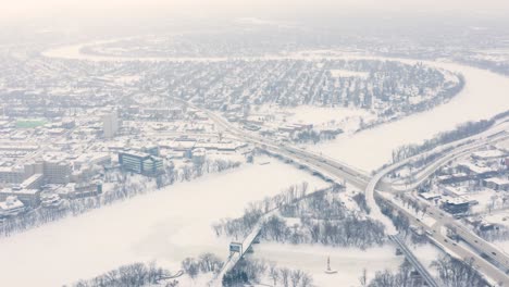 Static-aerial-shot-of-the-red-river-snaking-through-Winnipeg-Manitoba-during-an-ice-storm