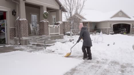 Senior-woman-shoveling-snow-from-her-driveway