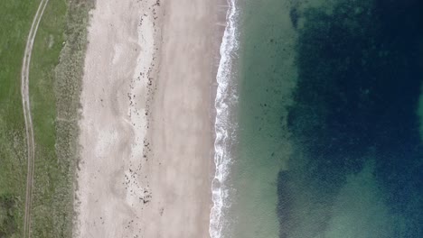 Top-down-aerial-shot-flying-over-a-sand-beach-on-the-coast-of-Scotland