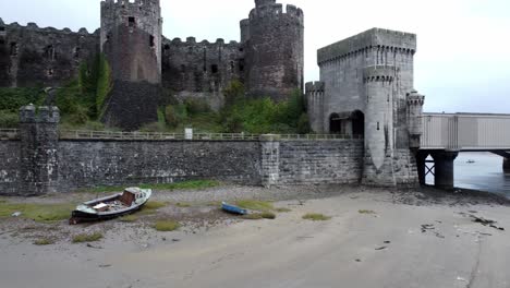 Historische-Conwy-Castle-Luftaufnahme-Der-Wahrzeichen-Stadtruine-Steinmauer-Zinnen-Touristenattraktion-Niedrige-Umlaufbahn-über-Festgemachten-Booten