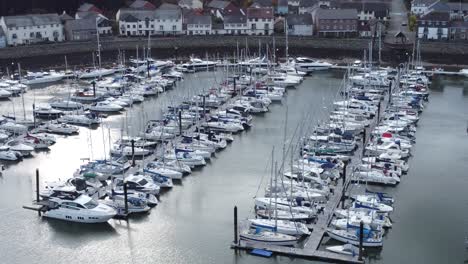 Malerisches-Luxuriöses-Hafenapartmentdorf-Am-Wasser-Yachten-Und-Segelboote-Unter-Der-Bergküste,-Die-Nach-Vorne-Abfällt,-Luftbild