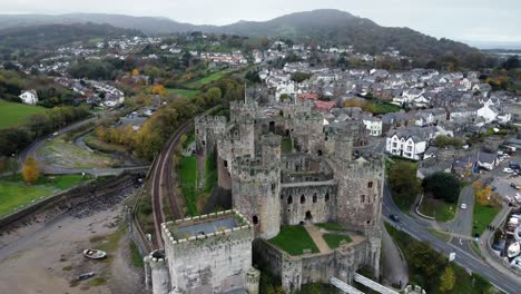 Historic-Conwy-castle-aerial-view-of-Landmark-town-ruin-stone-wall-battlements-tourist-attraction-high-to-low-descend-left