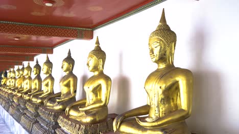 A-row-of-golden-Buddha-sculptures-in-a-temple-in-Thailand