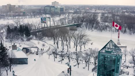 Slow-aerial-pan-around-blowing-Canadian-flag-in-downtown-Winnipeg-in-winter