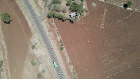 Top-down-aerial-of-traffic-driving-over-busy-road-in-rural-Africa