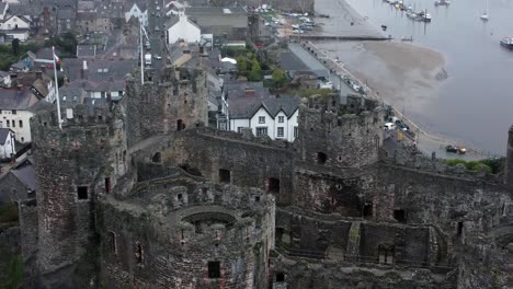 Historic-Conwy-castle-aerial-view-of-Landmark-town-ruin-stone-wall-battlements-tourist-attraction-Birdseye-pull-away