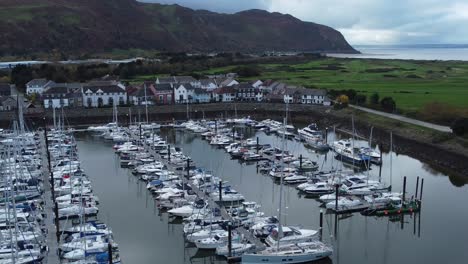 Luxurious-yachts-moored-in-wealthy-Welsh-mountain-marina-aerial-view-orbiting-left-shot