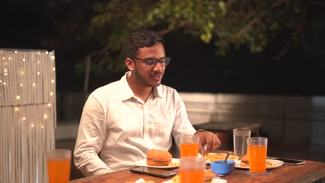Indian-boy-eating-burger-and-fries-smiling-face-junk-food-orange-juice