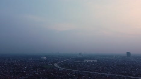 aerial-drone-shot-of-a-city-at-night-with-twilight-sky