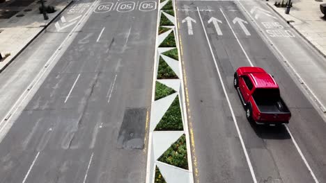 Aerial-View-of-a-Red-Truck-on-a-Main-Avenue-and-a-Man-on-the-Crosswalk