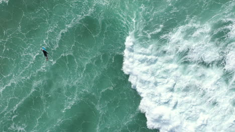 4k-Luftaufnahme-Von-Oben-Eines-Surfers,-Der-Mit-Seinem-Surfbrett-In-Australien-Zum-Tiefen-Ozeanwasser-Paddelt