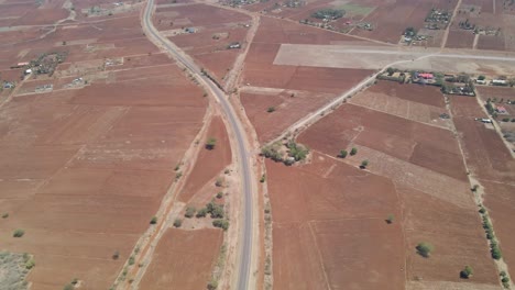 Long-aerial-over-a-highway-running-through-a-beautiful-countryside-in-rural-Kenya