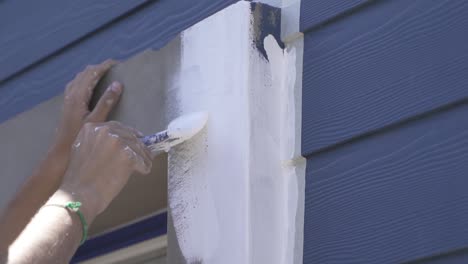 Slow-motion-shot-of-male-person-painting-window-frame-with-brush-in-white-color