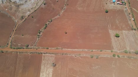 Top-down-aerial-over-arid-farmlands-and-dirt-roads