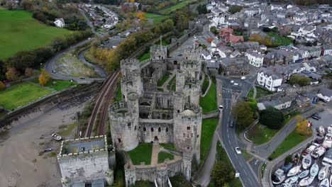 Historic-Conwy-castle-aerial-view-of-Landmark-town-ruin-stone-wall-battlements-tourist-attraction-high-orbit-left