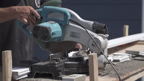 Close-up-of-labourer-cutting-piece-of-wood-with-electric-circular-saw-in-slow-motion