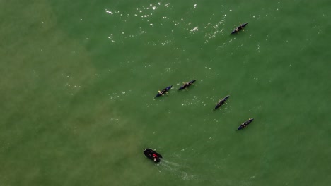 Schwarze-Boote-Des-Ruderteams,-Das-Auf-Meeresgewässern-übt