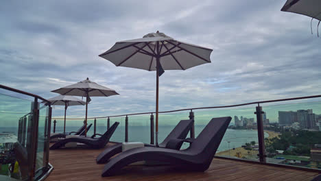 bed-pool-with-umbrella-around-swimming-pool-with-sea-background---holidays-and-vacation-concept