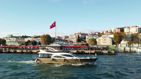 Yacht-on-Bosporus-Strait-in-Istanbul-with-Turkish-Flag-in-Background