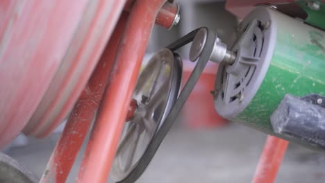 Close-up-of-concrete-mixer-motor-belt-spinning-in-slow-motion