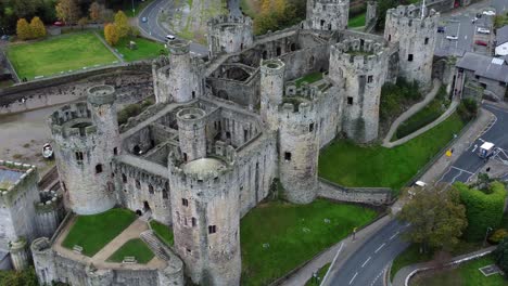 Historic-Conwy-castle-aerial-view-of-Landmark-town-ruin-stone-wall-battlements-tourist-attraction-zooming-in-close