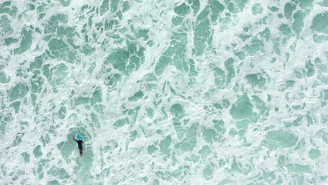 4K-Drohne-Draufsicht-Eines-Surferpaddels-Im-Tiefseewasser-Mit-Seinem-Surfbrett-In-Australien