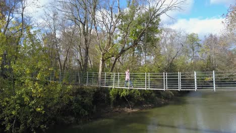 Suspension-bridge-above-river-water-on-park-footbridge-walking-path