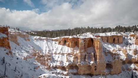 Timelapse,-Bryce-Canyon-National-Park,-Utah-USA-on-Sunny-Winter-Day,-Snow-Capped-Red-Rock-Sandstone-Cliffs-and-Caves-Under-Moving-Clouds